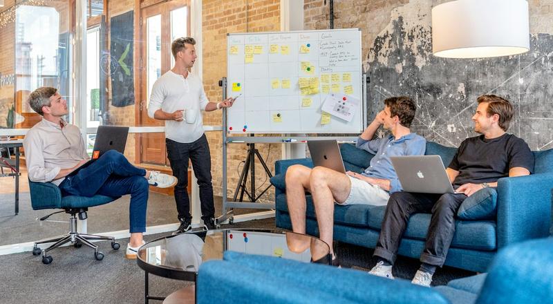 Media team planning a campaign around a whiteboard